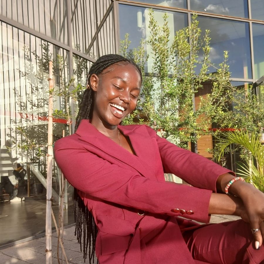 Scarlet Patience laughing, in a burgundy suit