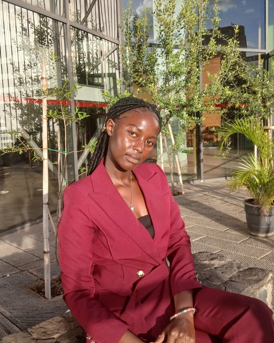 Scarlet Patience in a burgundy suit